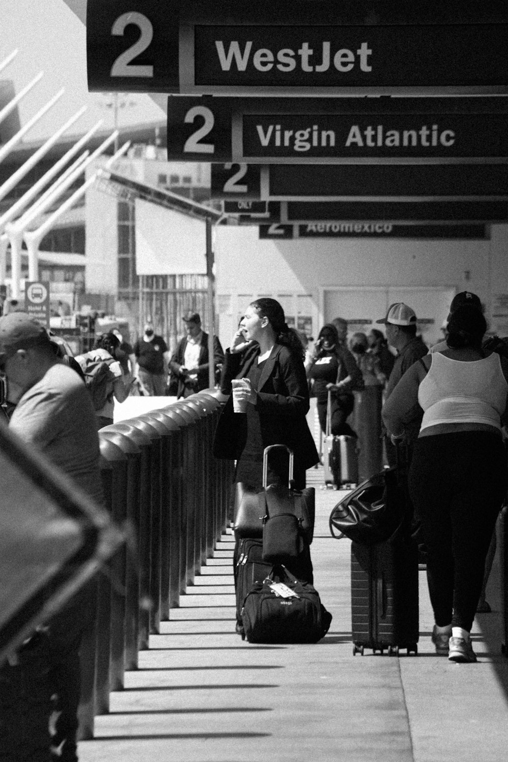 a black and white photo of people waiting at an airport