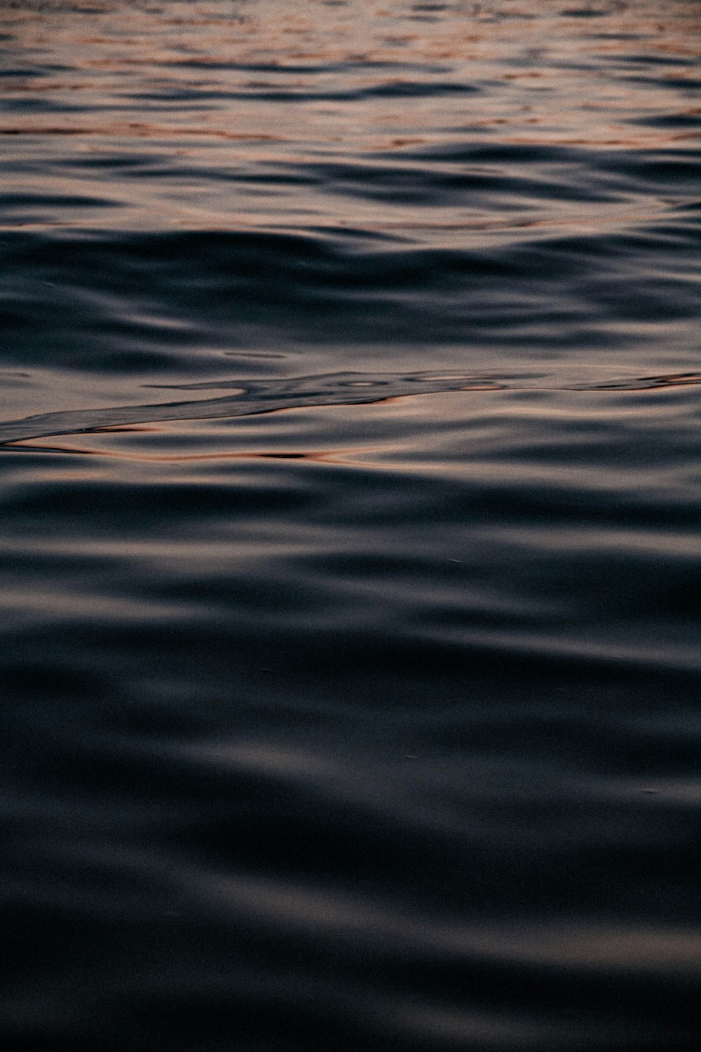 a large body of water with a boat in the distance