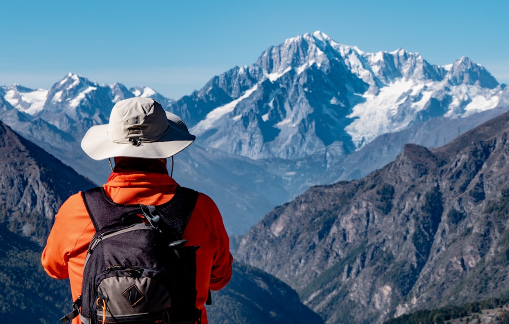 a person with a backpack looking at the mountains