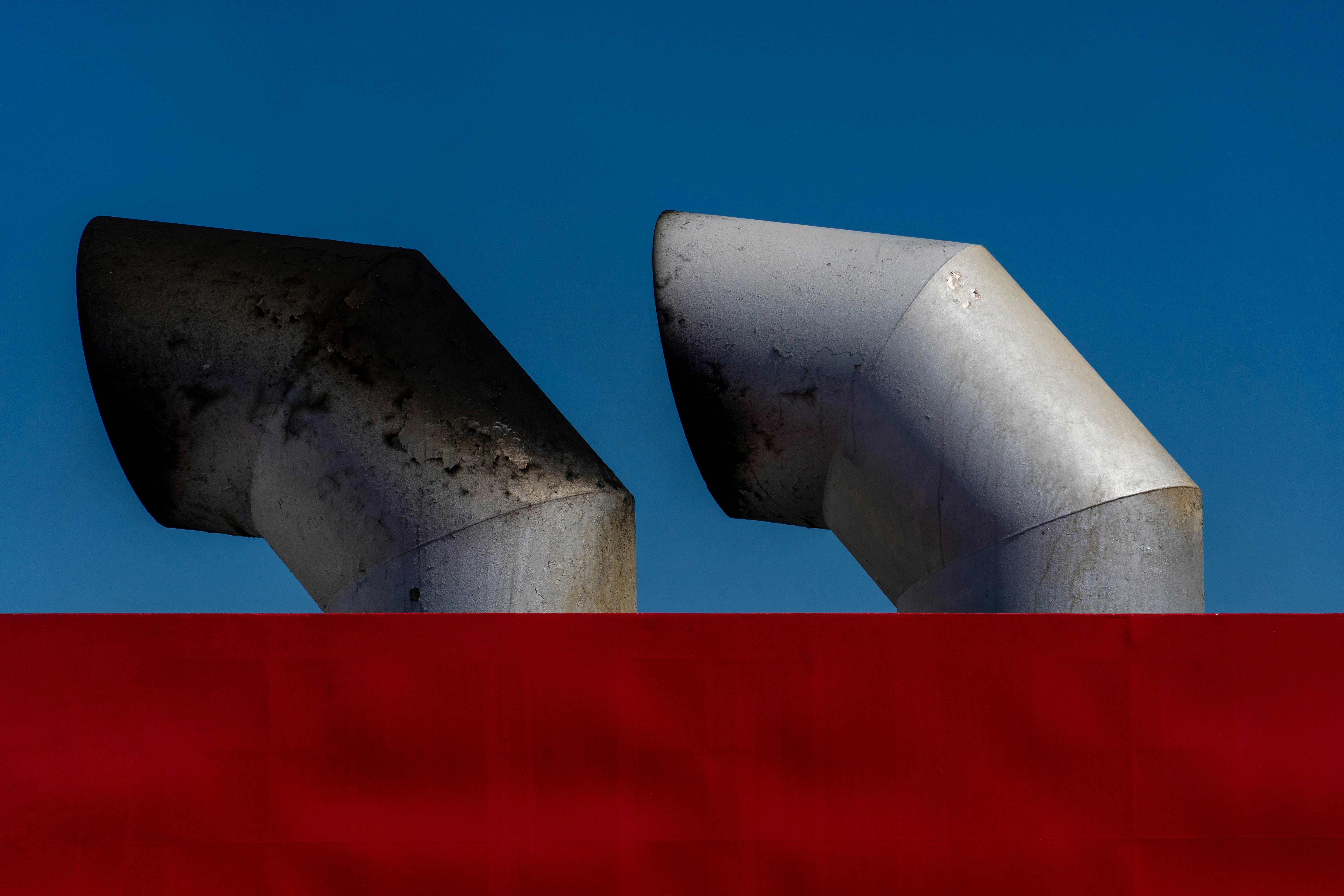 a close up of a metal pipe on top of a red wall