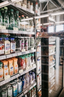 a woman is looking at a display of drinks