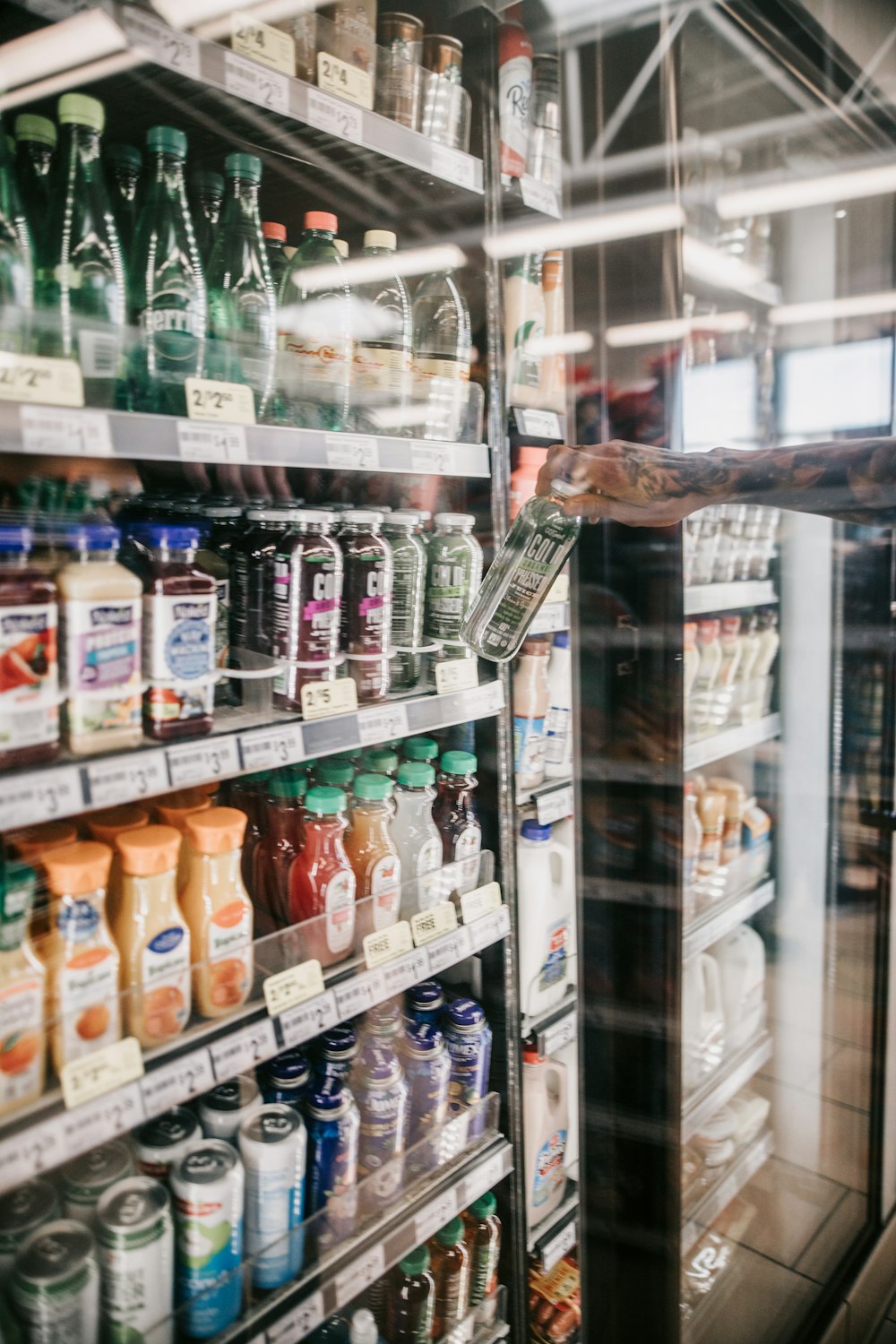 a woman is looking at a display of drinks