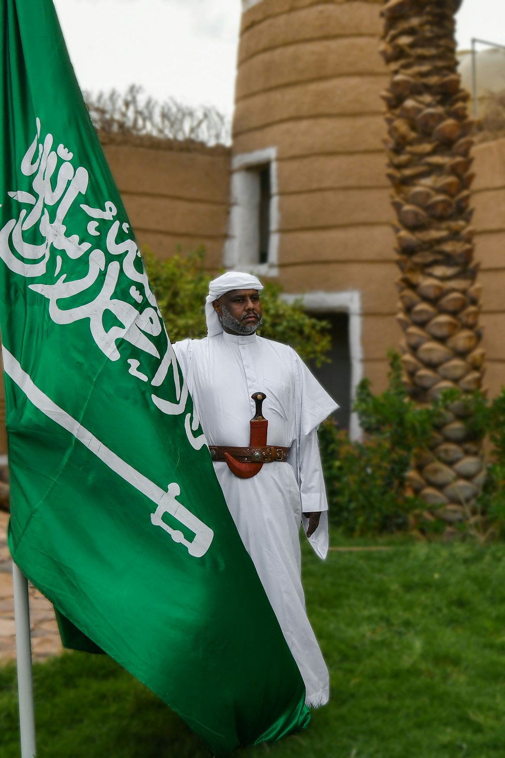 a man standing next to a green flag