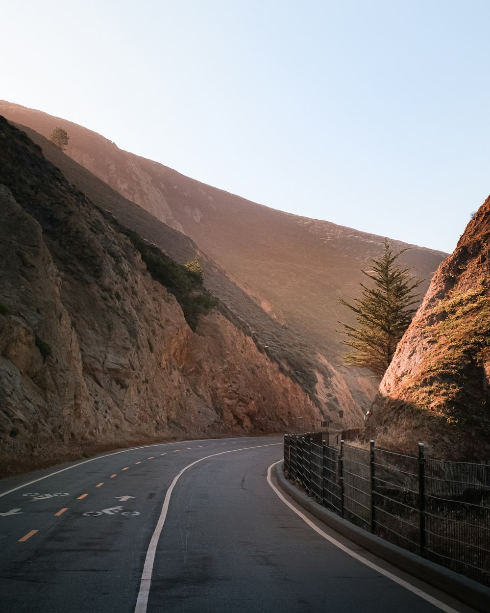 a winding road with a mountain in the background