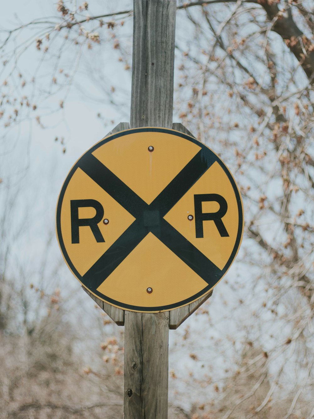 a railroad crossing sign on a wooden pole