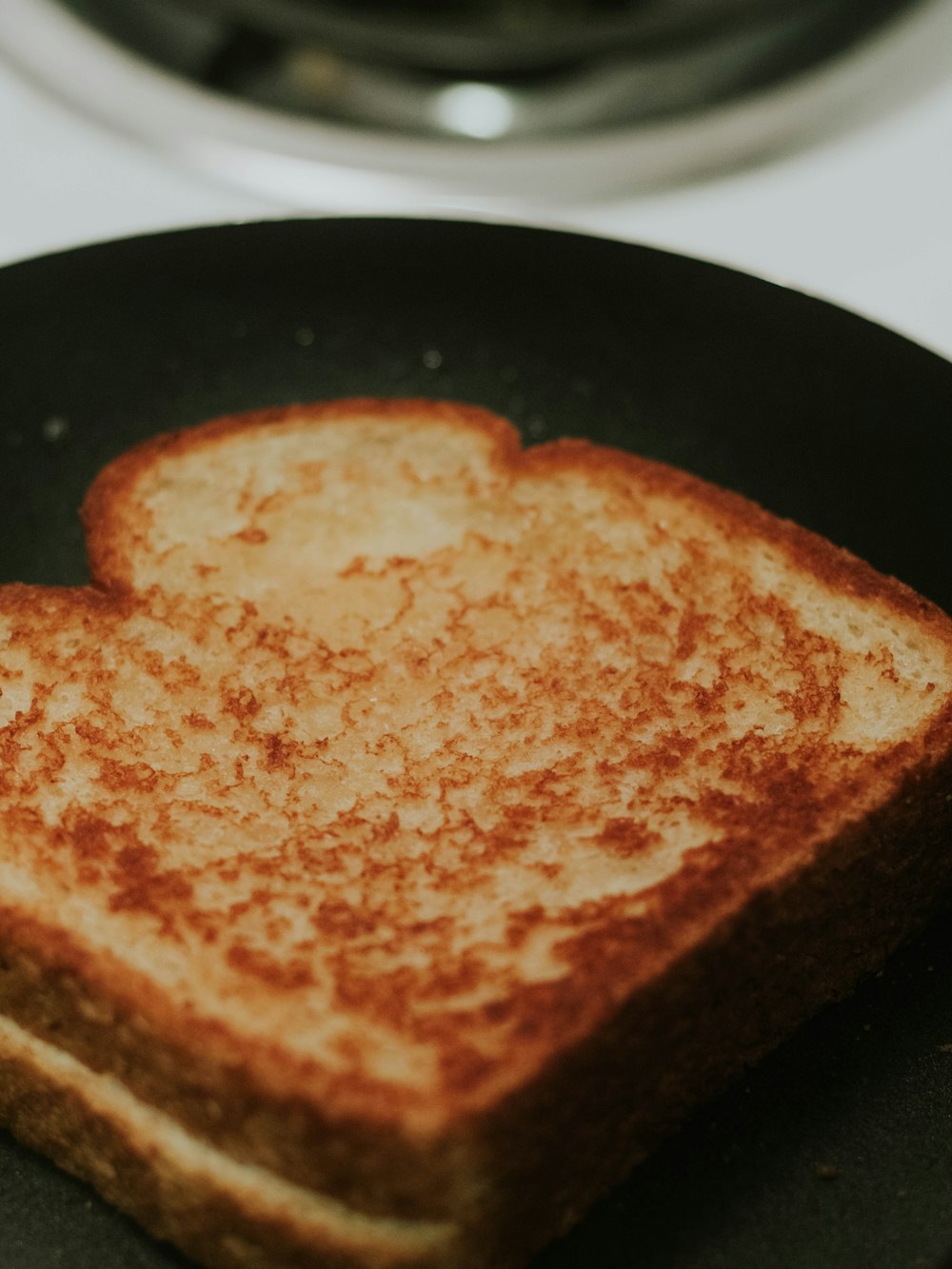 a heart shaped grilled cheese sandwich on a black plate