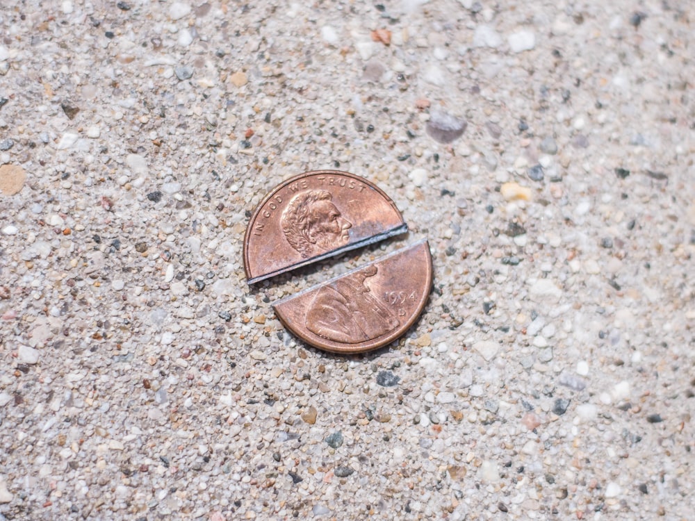 a penny sitting on the ground next to a pair of scissors