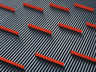A pattern of parallel black and white stripes with evenly spaced horizontal red bars overlaying them, creating a striking geometric design.