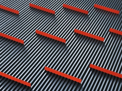 A pattern of parallel black and white stripes with evenly spaced horizontal red bars overlaying them, creating a striking geometric design.