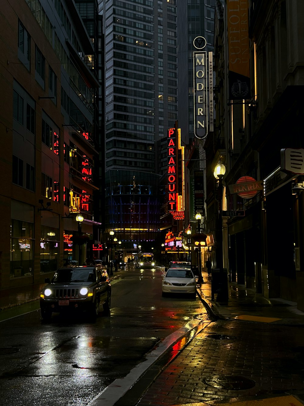 a city street filled with lots of traffic next to tall buildings