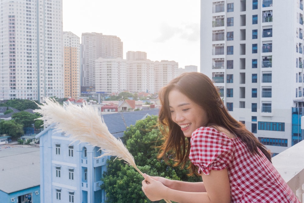 a woman holding a feather on top of a roof