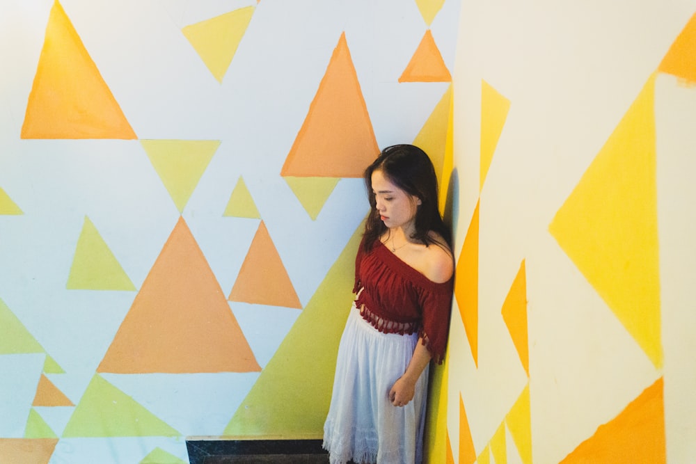 a little girl standing in front of a colorful wall