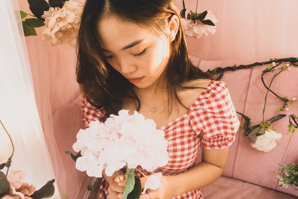 a young woman holding a bouquet of flowers