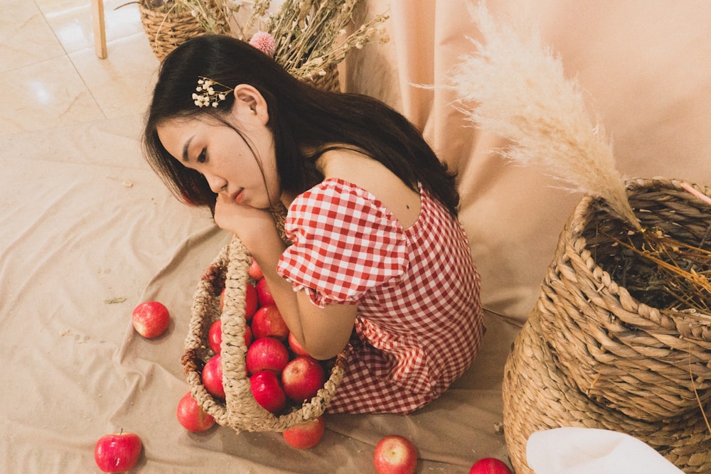 a woman is sitting on the floor with apples