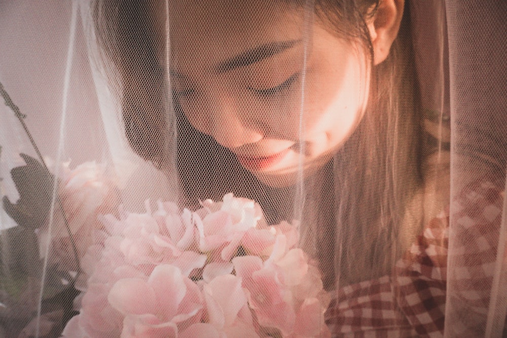 a woman holding a bouquet of pink flowers