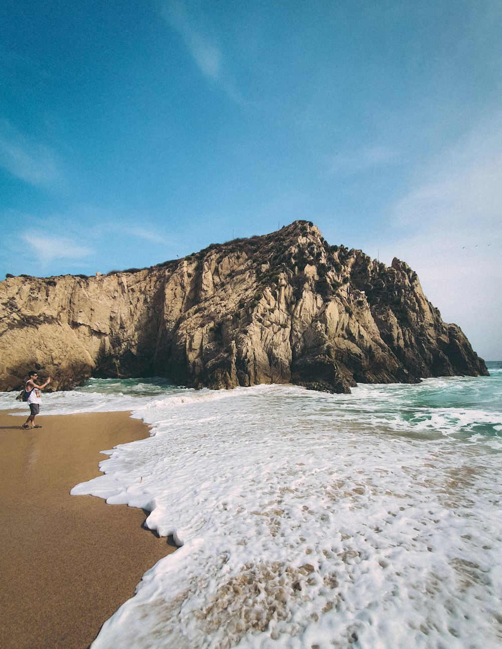 a person standing on a beach next to the ocean