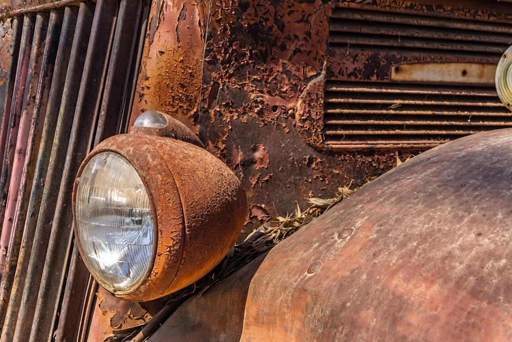an old rusted truck with a light on the front