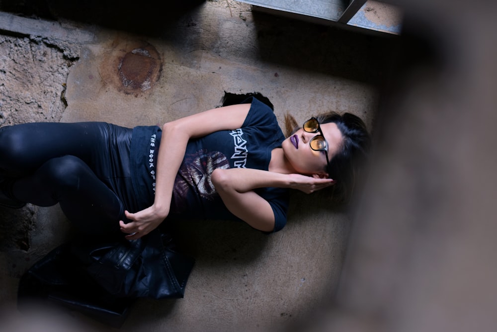 uma mulher deitada no chão usando óculos de sol