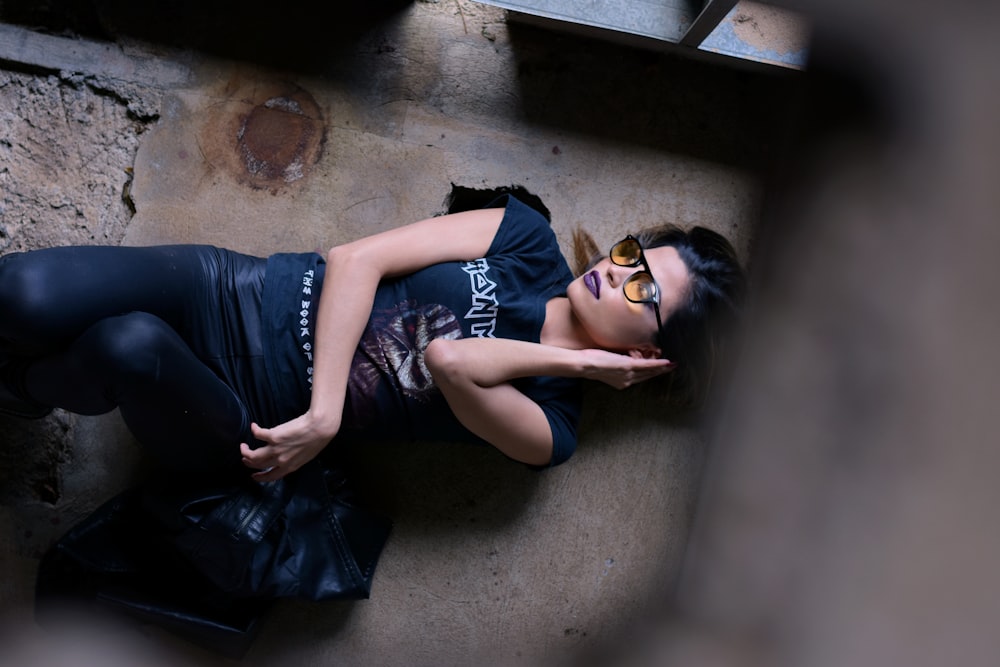 a woman laying on the ground wearing sunglasses