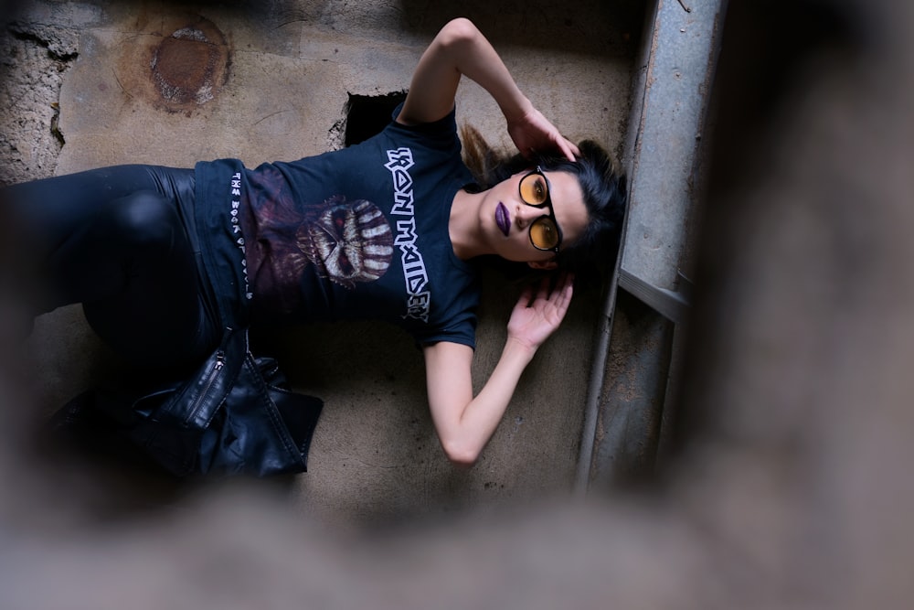 a woman laying on the ground wearing a black shirt