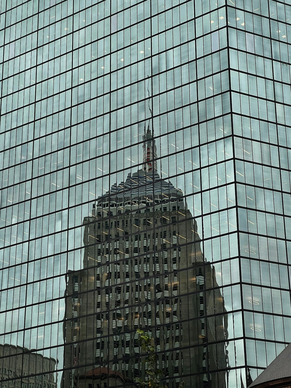 a building is reflected in the glass windows of another building