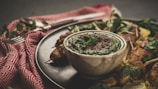 Spicy green chili chutney served in a rustic bowl with fresh herbs.