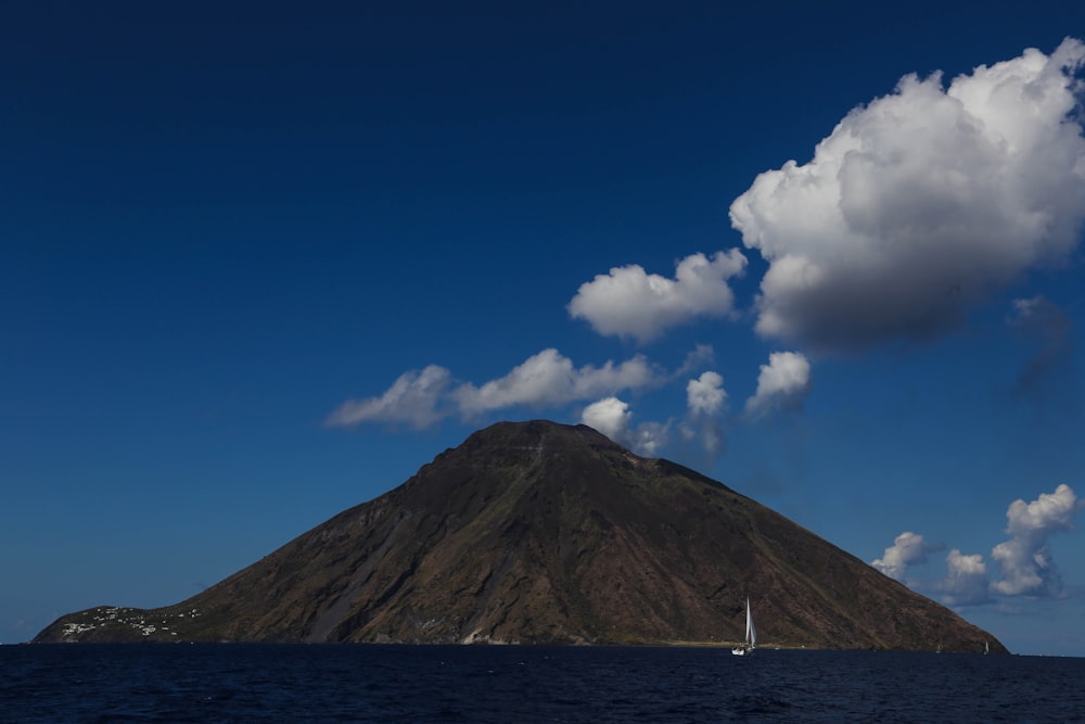 a sailboat in the water near a mountain