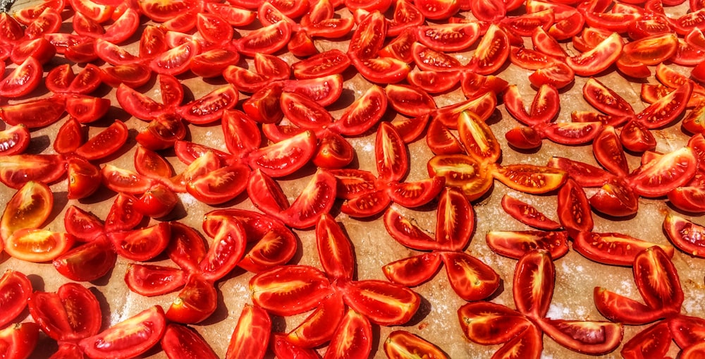 a table topped with sliced tomatoes on top of a wooden cutting board