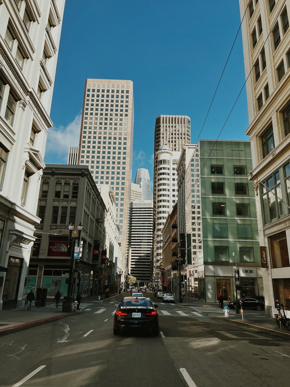 a car driving down a city street next to tall buildings