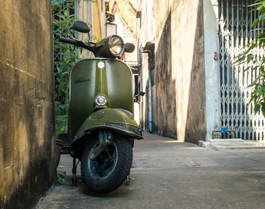 a green scooter parked on the side of a building