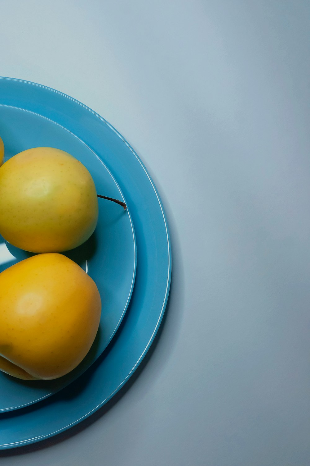a blue plate topped with yellow fruit on top of a table