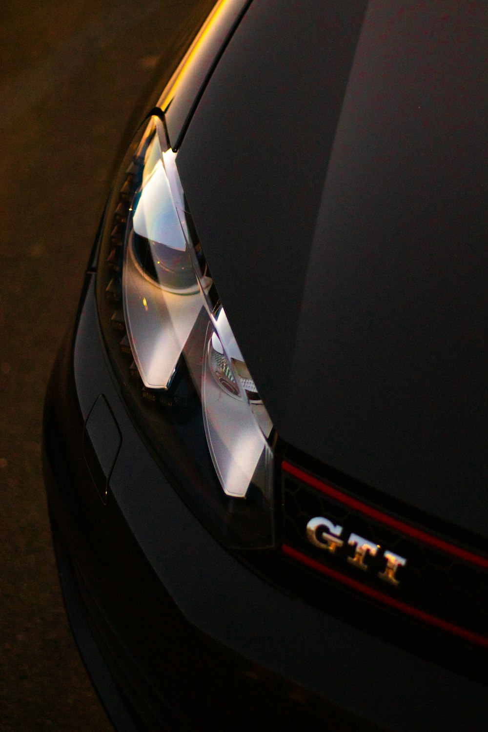 a close up of a car's headlights on a street