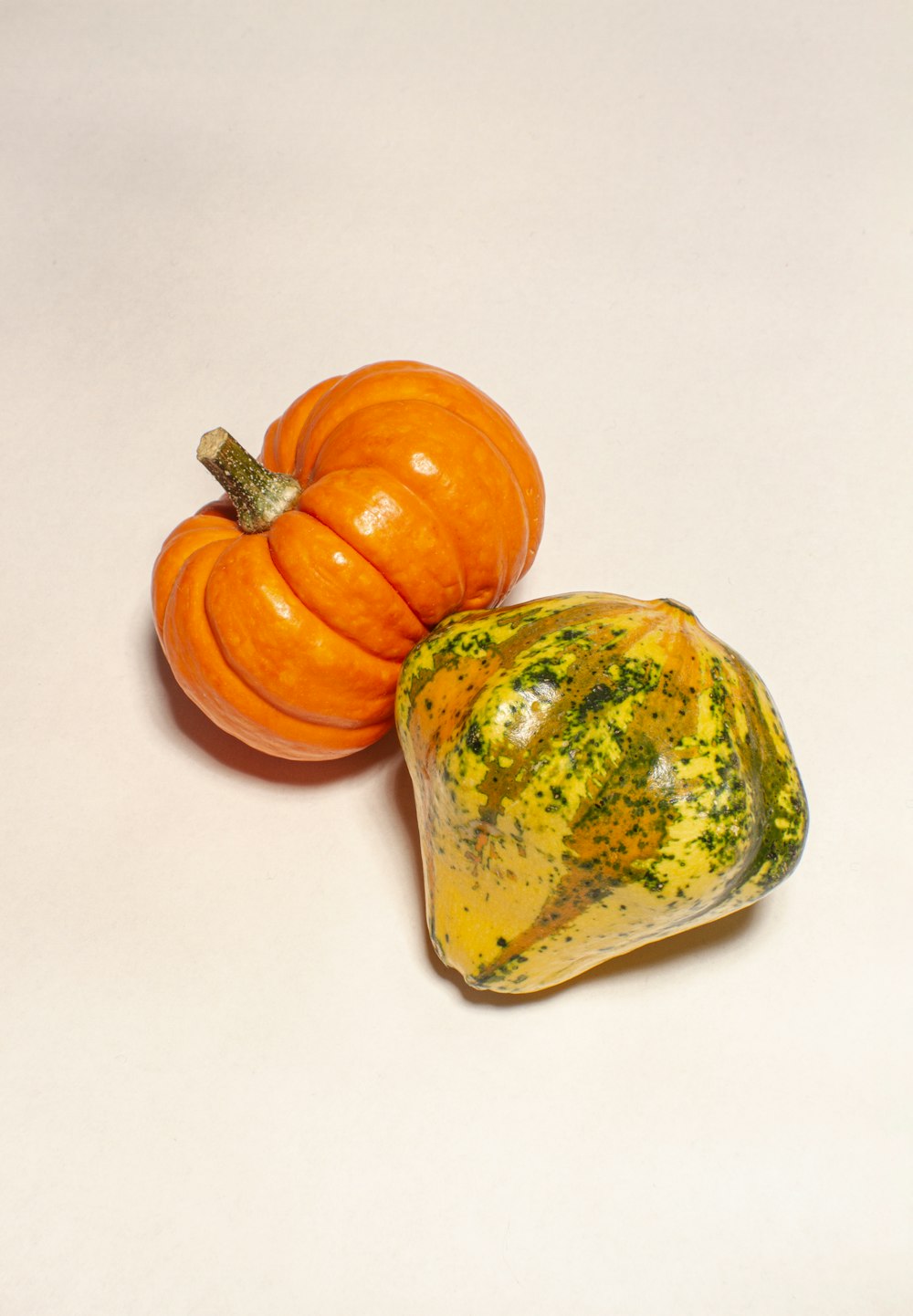 a couple of small pumpkins sitting on top of a table