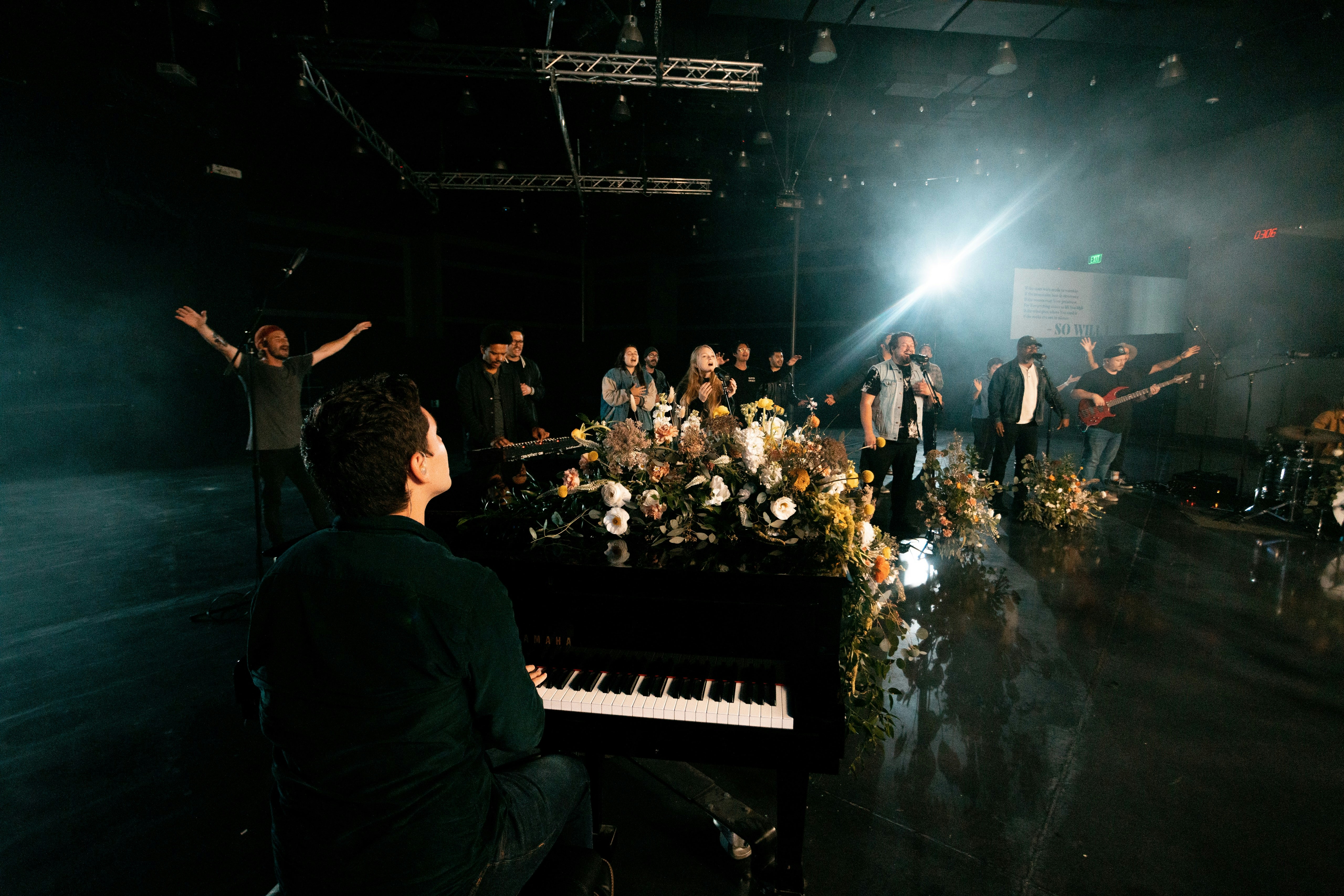 Un grupo de personas de pie alrededor de un piano