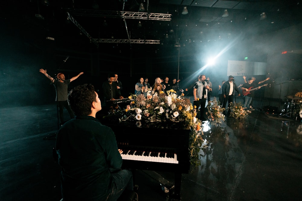 a group of people standing around a piano