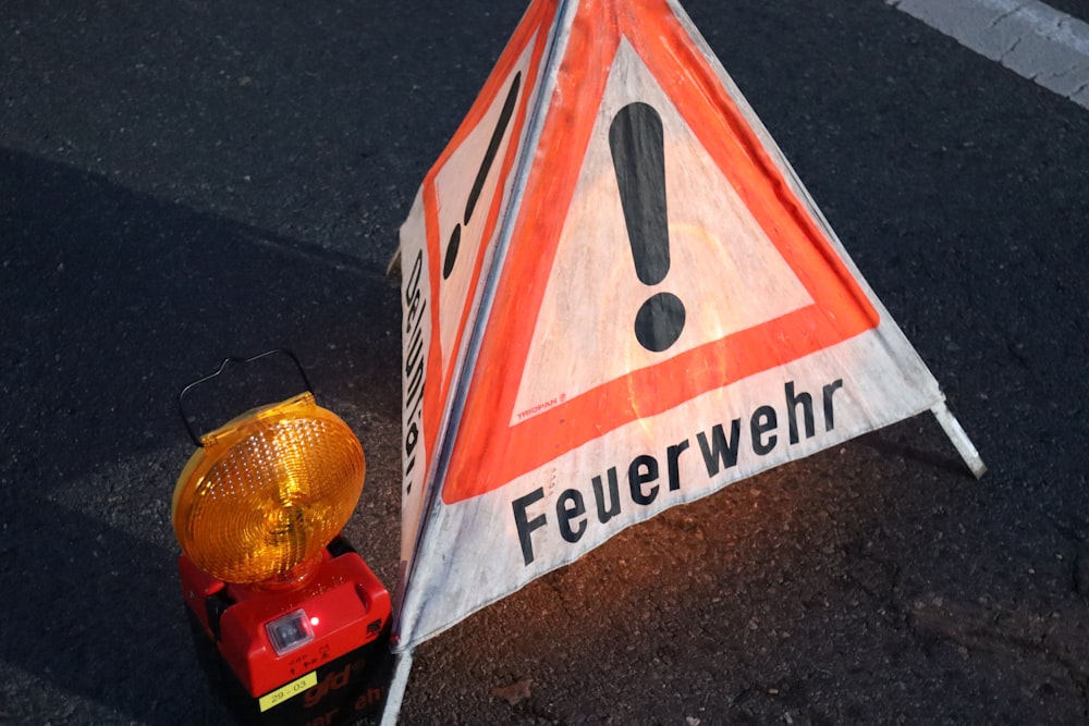 a warning sign sitting on the side of a road