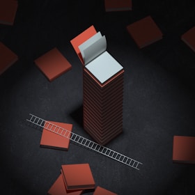 A tall stack of orange books with an open white book on top is surrounded by more books laid flat. A small ladder leans against one of the flat books, all set against a dark backdrop.