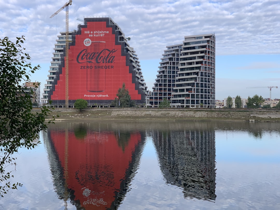 a large coca - cola advertisement is reflected in a body of water, Reflections