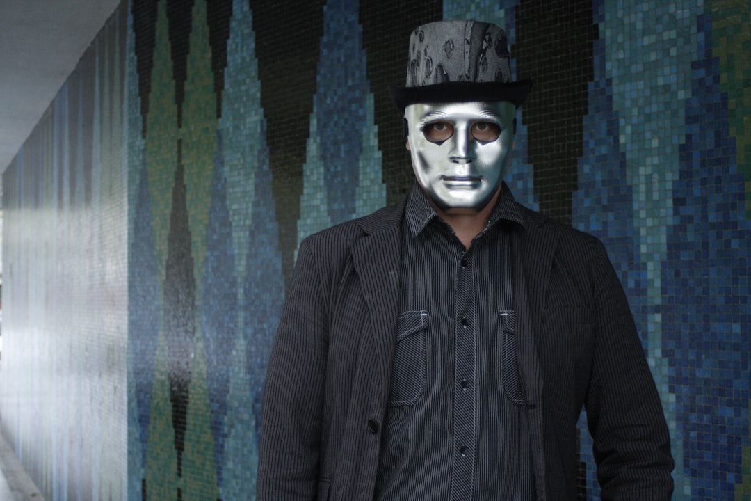 a man wearing a white mask and a top hat,