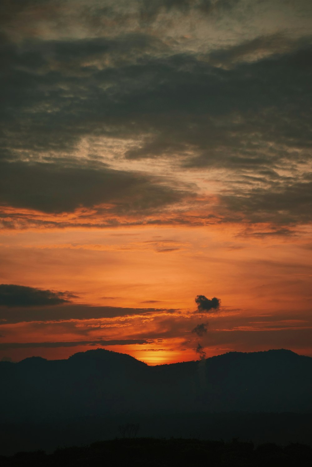 the sun is setting over a mountain range