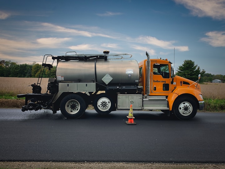 A TMA truck positioned on a busy highway with bright safety orange and yellow markings under a clear sky.