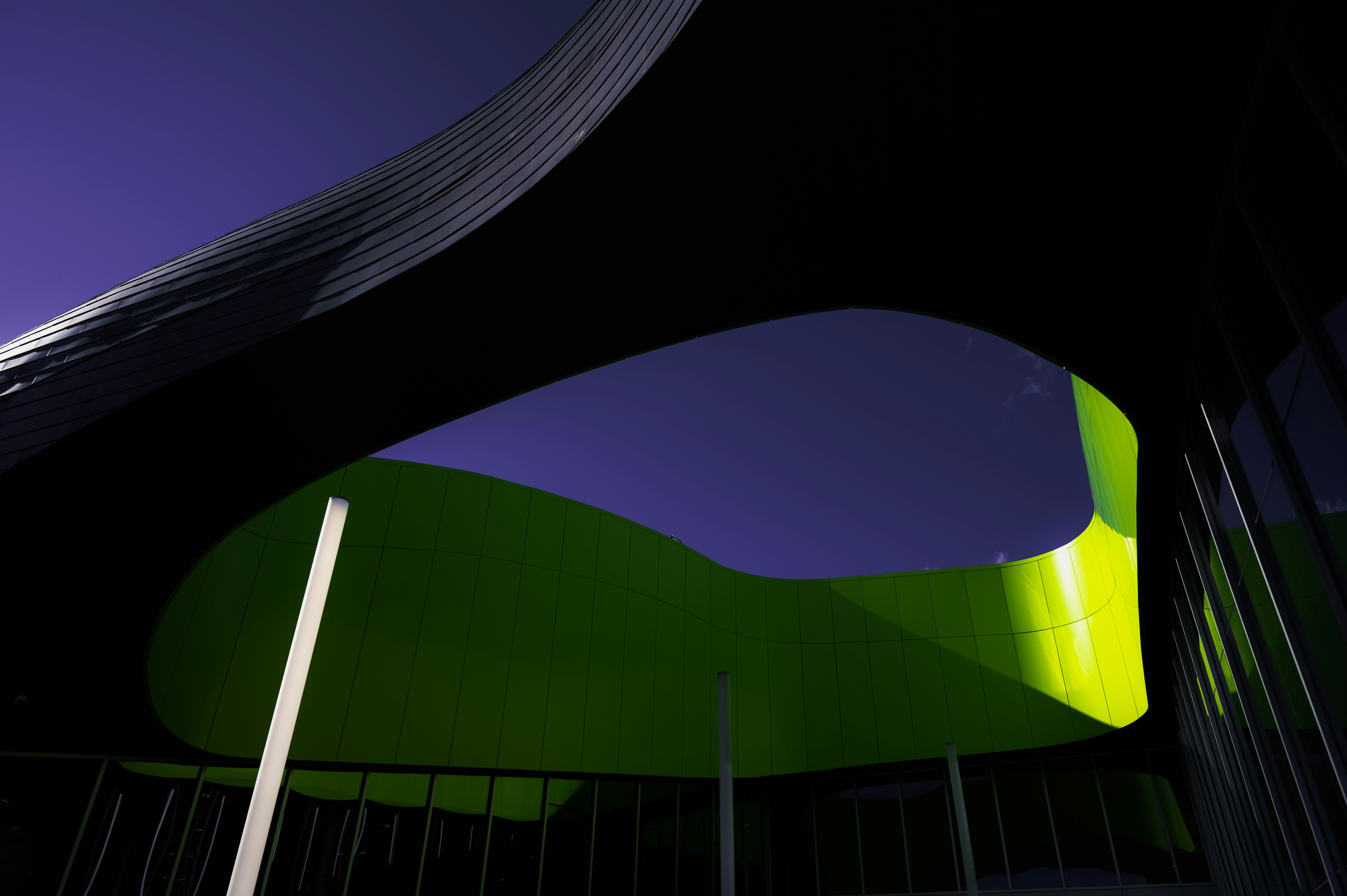 a large green building with a curved roof