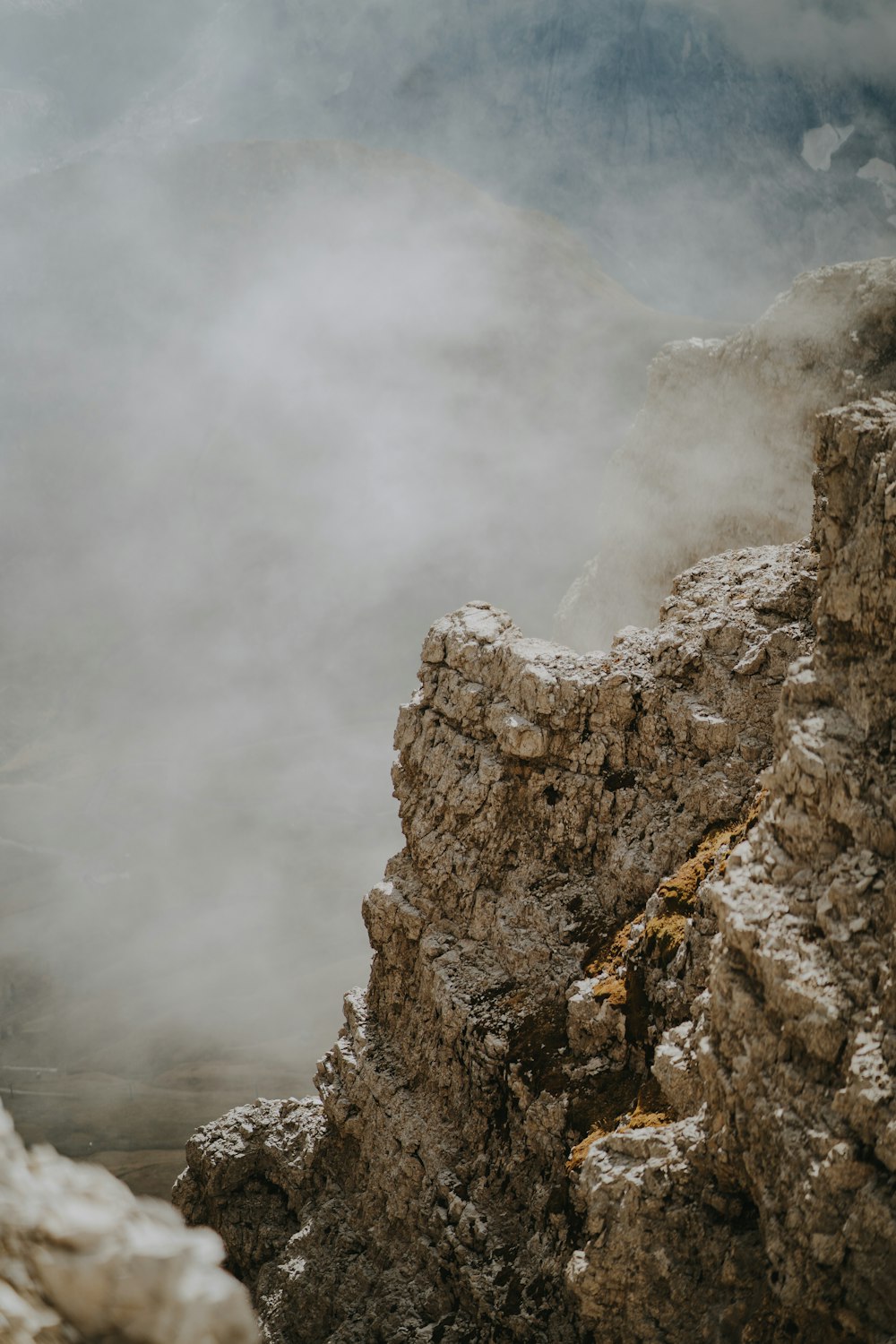 Un homme debout au sommet d’une falaise rocheuse