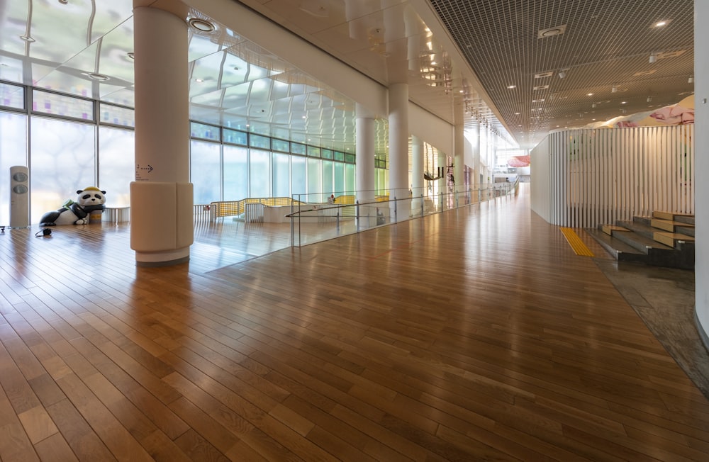 a large room with wooden floors and large windows