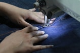 a woman using a sewing machine to sew jeans