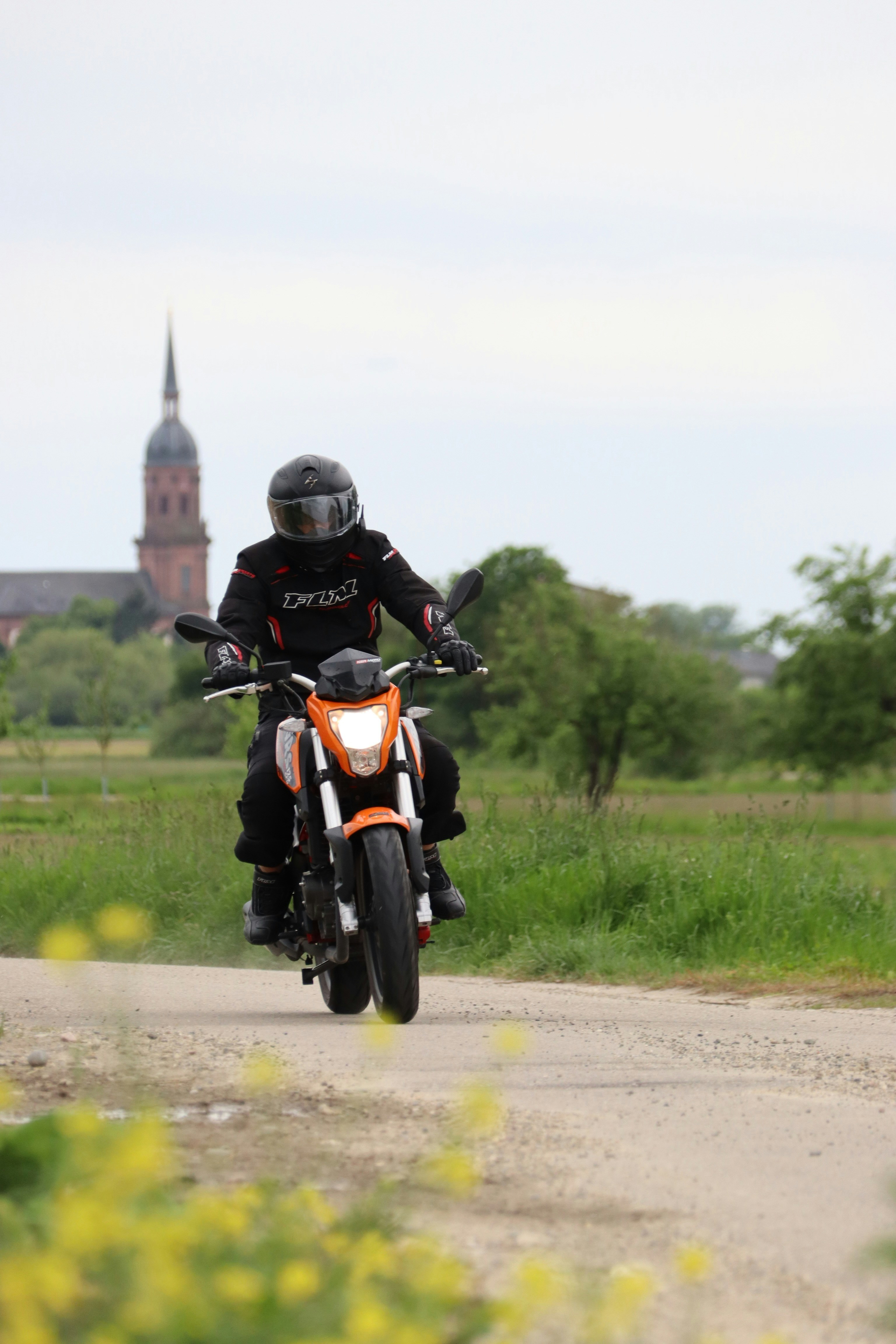 a man riding a motorcycle down a dirt road