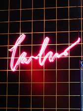 Sleek storefront sign glowing with magenta and gold accents against a charcoal background.