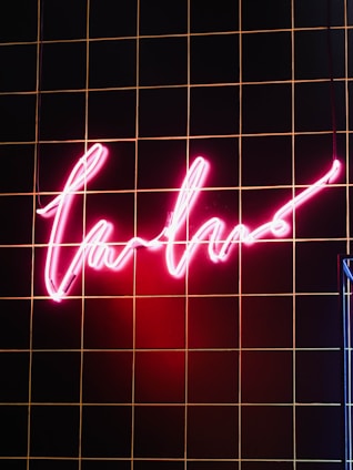 A stylish pink neon sign illuminating a modern space.