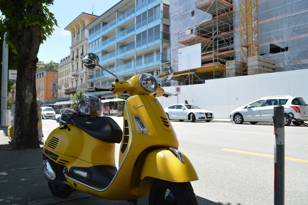 a yellow scooter parked on the side of the road