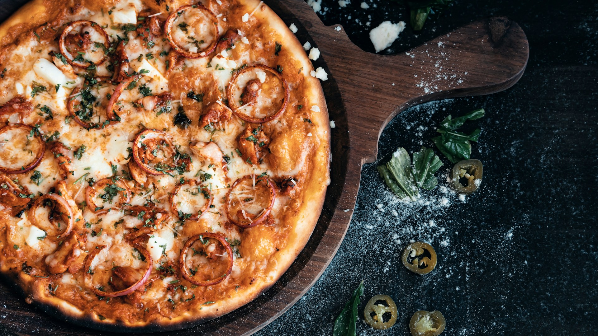 a pizza sitting on top of a wooden cutting board
